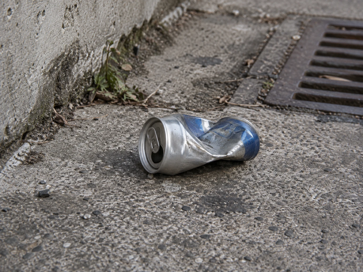 Illustrative photograph of a crushed can on concrete